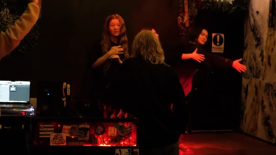 izza gara och dansare i mörksatt scen